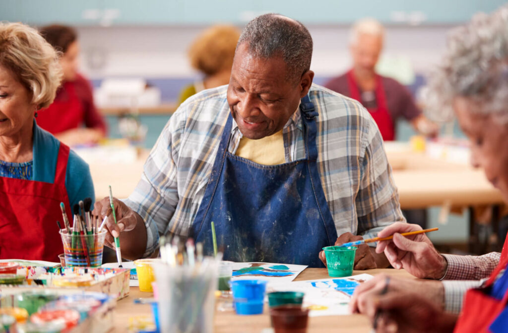 A group of seniors attending a painting class in a memory care home.