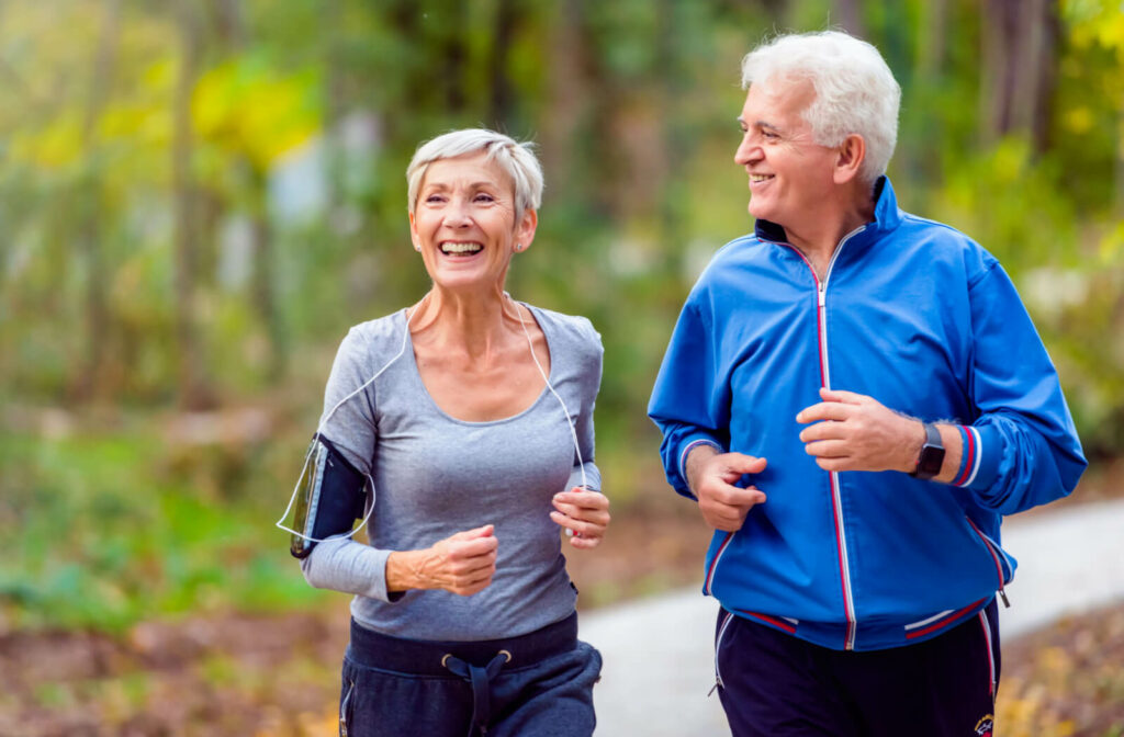 Elderly couple jogging together in the woods