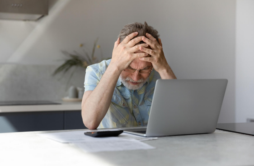 A senior man having trouble focusing on the contents of his laptop which could be a sign of Alzheimer's.